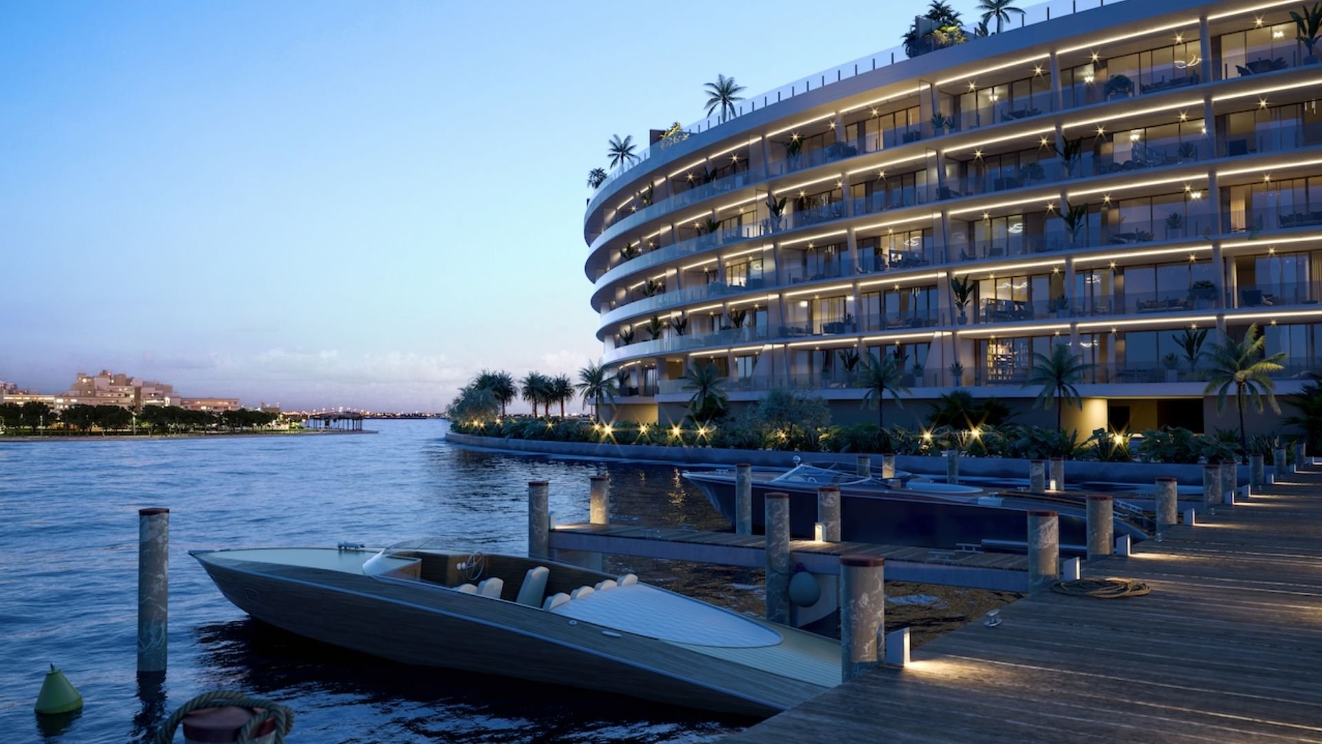 Luxury waterfront apartment building at dusk with illuminated balconies